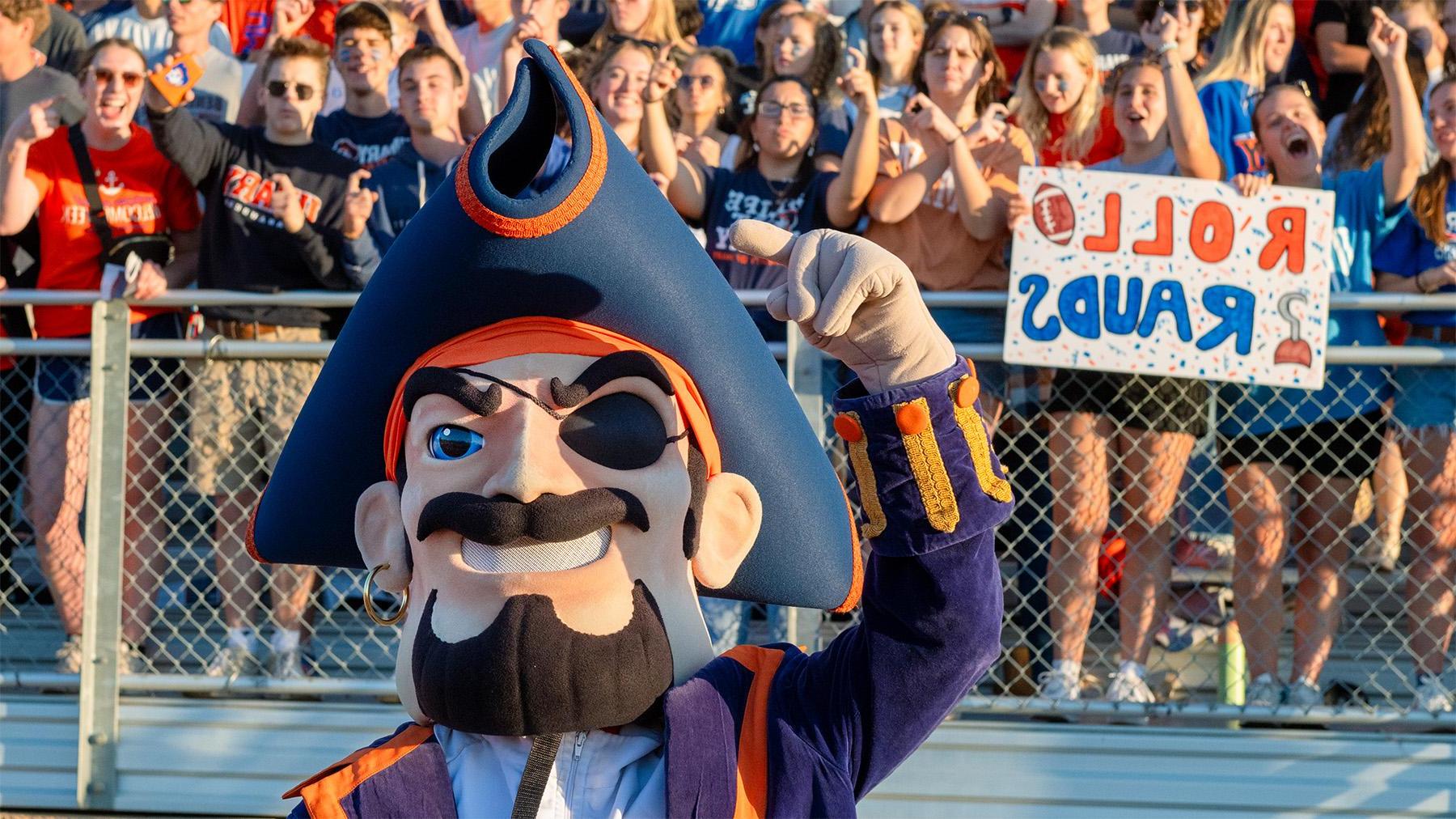 Max at a Football game with cheering students in the background.